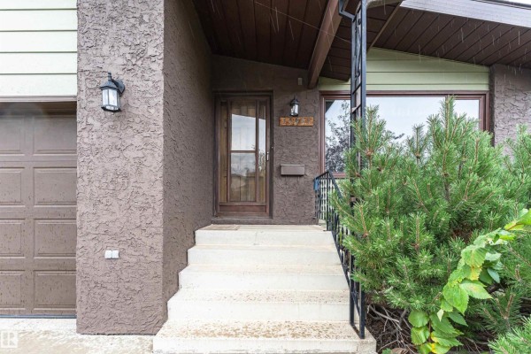 Entrance detail showing the door, address number, and nearby shrubbery. - 15903 111 St Nw, Edmonton