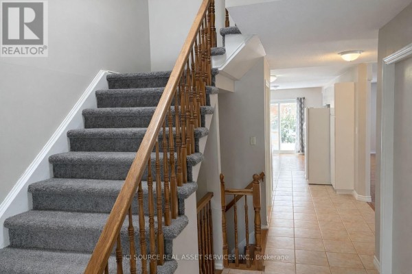 Carpeted staircase leading to upper level with tiled entryway - 1593 Murphy Road, Sarnia
