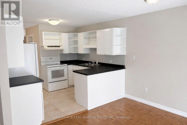 Kitchen with white cabinets, black countertops, and appliances - 1593 Murphy Road, Sarnia