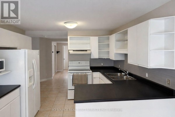 Open kitchen layout featuring white cabinetry and dual sinks - 1593 Murphy Road, Sarnia