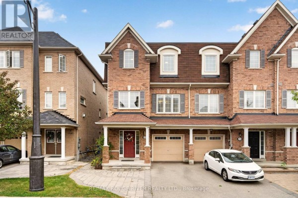 Brick townhouse exterior with a covered front porch, double garage, and paved driveway. - 1594 Brandy Court, Pickering