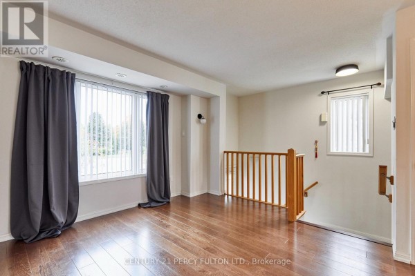 Living area with large window, dark grey curtains, and hardwood floors. - 15951 Bayview Avenue, Aurora