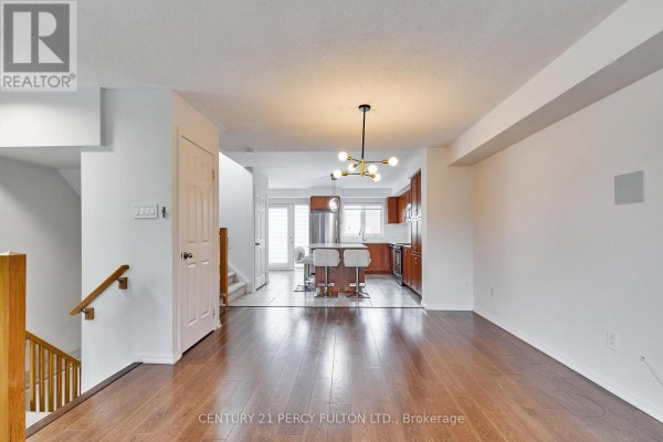 Open concept living space with hardwood floors and view of kitchen area. - 15951 Bayview Avenue, Aurora