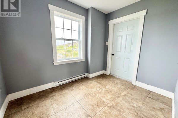 Interior view of a small room with grey walls, a beige tile floor, a white door, and a window. - 15a Main Street, Tilting