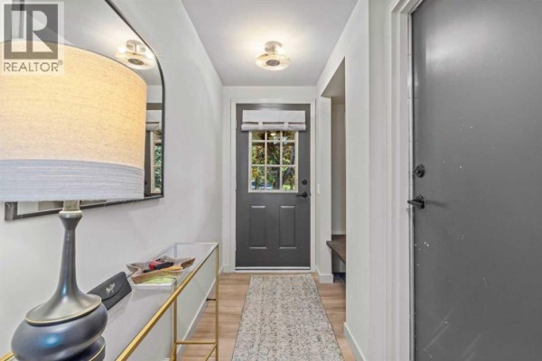 View of the entryway with a dark grey door and a console table. - 16, 140 Point Drive Nw, Calgary