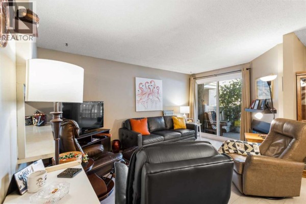 Living room with leather sofas, recliners, and a sliding glass door. - 16, 3015 51 Street Sw, Calgary