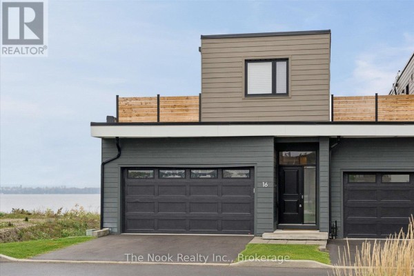 Exterior of townhouse unit 16 with dark grey siding, garage door, and entrance. - 16 - 19 West Street N, Kawartha Lakes