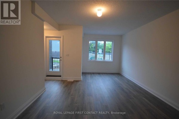 Interior view of living room with dark wood floors and patio door. - 16 - 199 Ardagh Road, Barrie