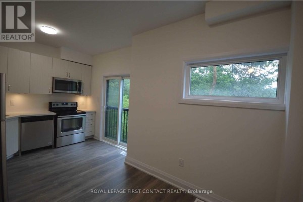Open concept kitchen and dining area with stainless steel appliances. - 16 - 199 Ardagh Road, Barrie