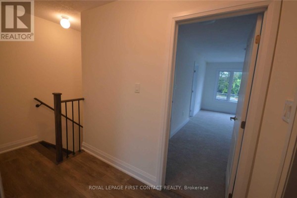 Hallway view looking towards a staircase and a doorway to a room. - 16 - 199 Ardagh Road, Barrie