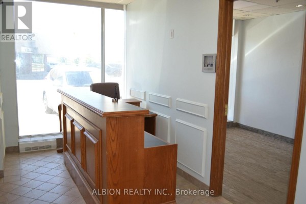 Reception desk with marble top and wood paneling in a commercial space. - 16 - 2001 Albion Road, Toronto