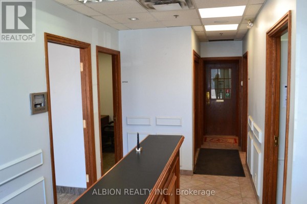 Interior hallway of commercial building with multiple doors and light blue walls. - 16 - 2001 Albion Road, Toronto