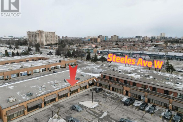 Exterior view of commercial building with multiple storefronts and snow-covered parking lot. - 16 - 3300 Steeles Avenue W, Vaughan