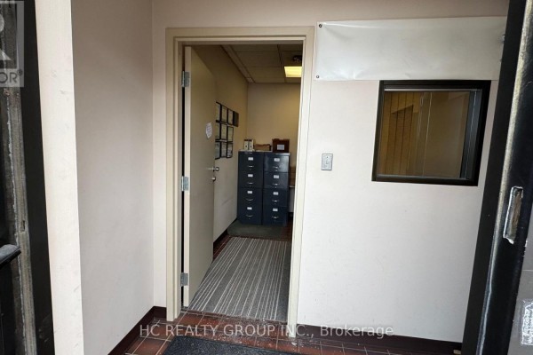 Interior office space with wooden furniture, printer, and window with blinds. - 16 - 3300 Steeles Avenue W, Vaughan