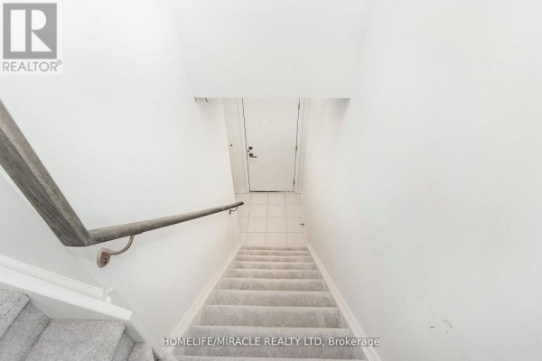 Entrance area with two doors labeled 1 and 16, surrounded by brick. - 16 - 3415 Ridgeway Drive, Mississauga