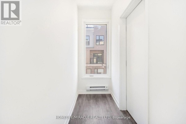 Staircase leading down to a door, with white walls and tiled flooring. - 16 - 3415 Ridgeway Drive, Mississauga
