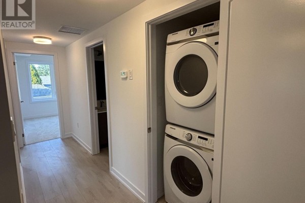 Hallway with stacked white Samsung washer and dryer in a closet. - 16 - 42 Lowes Road W, Guelph