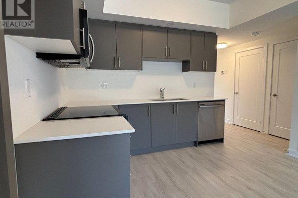 Kitchen with grey cabinetry, white countertops, stainless steel sink, and dishwasher. - 16 - 42 Lowes Road W, Guelph