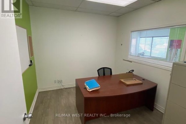 Empty office space with a curved desk, office chair, and window blinds on the right. - 16 - 500 Alden Road, Markham