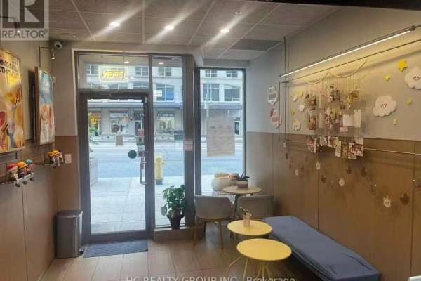 Interior view from entrance showing seating area, counter, and street view. - 16 - 5418 Yonge Street, Toronto