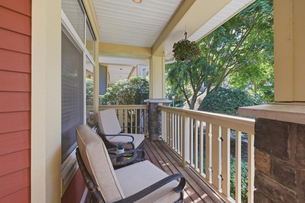 Entrance of a red townhouse with a blue door, porch, and seating area. - 16 15255 36 Avenue, Surrey