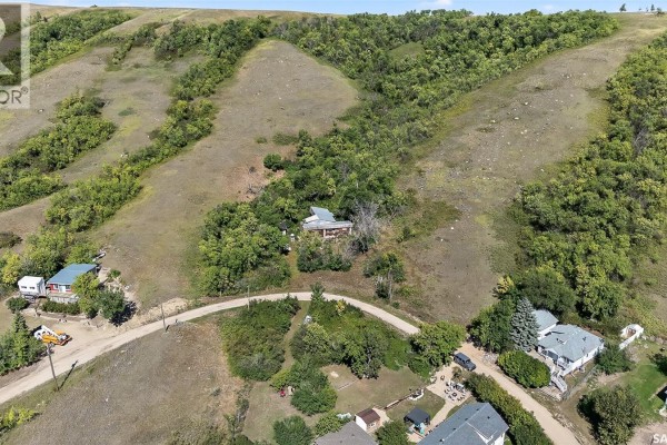 Aerial view showing multiple properties and homes along a winding road in a hilly, tree-covered landscape. - 16 Alice Crescent, North Grove