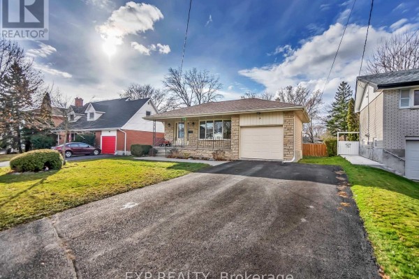 Drivway view of the bungalow showing the garage, front entrance, and lawn. - 16 Applewood Drive, Belleville