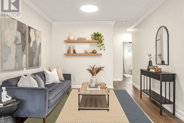 Living room with a blue sofa, two floating shelves, and a wood coffee table. - 16 Avis Crescent, Toronto