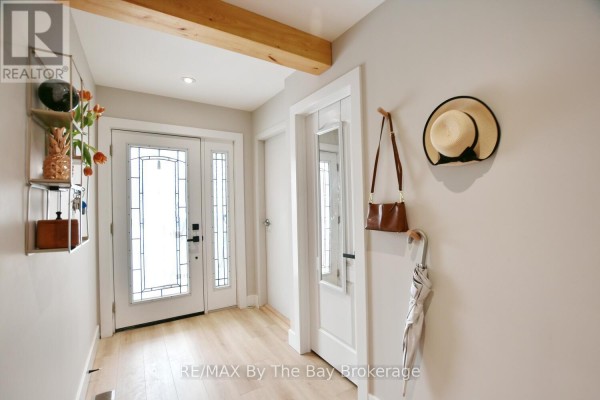 Interior entryway with a double glass door, mirror, hat rack, and decorative shelving. - 16 Caribbean Drive, Wasaga Beach