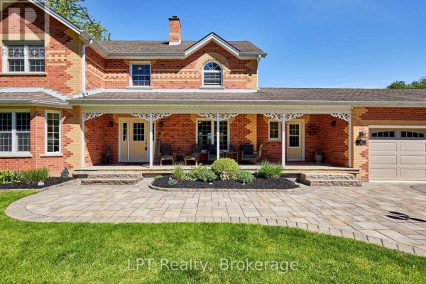 Dark wood kitchen cabinets, granite countertops, beige tiled backsplash, and stainless steel appliances. - 16 Cawkers Cove Road, Scugog