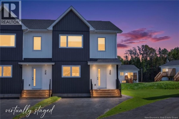 Rear view of adjacent townhouses with white siding, wooden decks, and black railings. - 16 Cedric Court, Dieppe