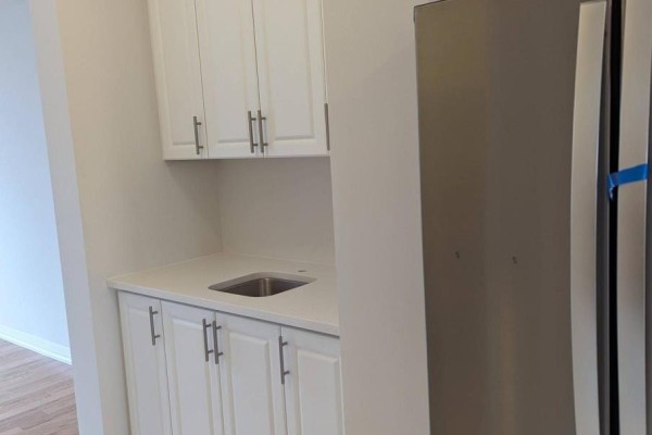 Wet bar area in the kitchen with white cabinetry, white countertop, and stainless steel sink. - 16 Coote Court, Ajax