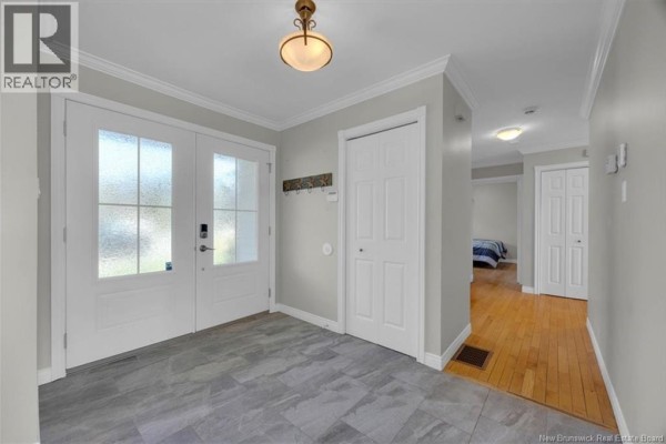 Interior entryway with light grey walls, a double glass door, and a tiled floor. - 16 Darling Court, Quispamsis