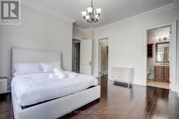 Bedroom with king bed, ornate cabinet, chandelier, and ensuite - 16 Fairview Avenue Richmond Hill