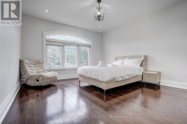 Bedroom with king bed, accent chair, arched window, and hardwood floors - 16 Fairview Avenue Richmond Hill