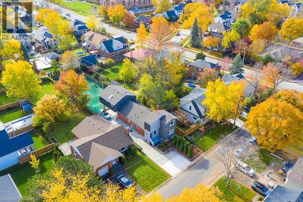Aerial view of a suburban neighborhood with houses, trees in fall colors, and a tennis court. - 16 Forest Hill Road, St  Catharines