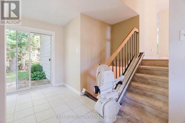 Interior view of a room with sliding glass doors to the backyard and a stairlift. - 16 Gold Crescent, Russell