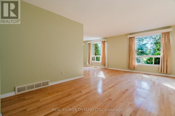 Living room with light green walls, hardwood floors, and large windows. - 16 Gold Crescent, Russell
