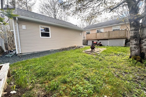 Side view of a beige bungalow with a backyard and detached garage. - 16 Hatcher Street, St  John S