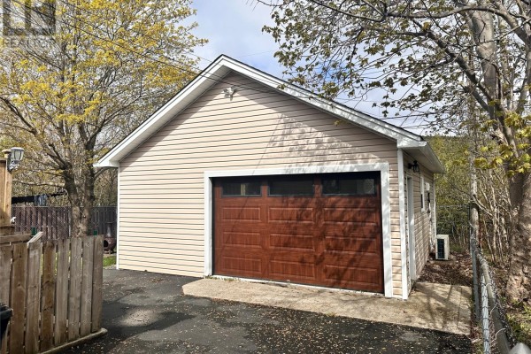 Exterior of a beige detached garage with a brown wooden door. - 16 Hatcher Street, St  John S