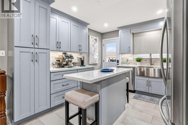 Kitchen with light blue cabinets, white countertops, stainless steel appliances, and an island. - 16 Juniper Drive, Stoney Creek
