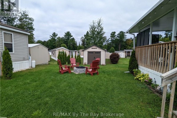 Backyard with fire pit, Adirondack chairs, and storage shed. - 16 Kenora Trail, Wasaga Beach