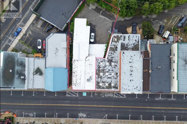 Overhead view of commercial properties along a street, highlighting a building with a courtyard and parking. - 16 Manitoba Street, Bracebridge)