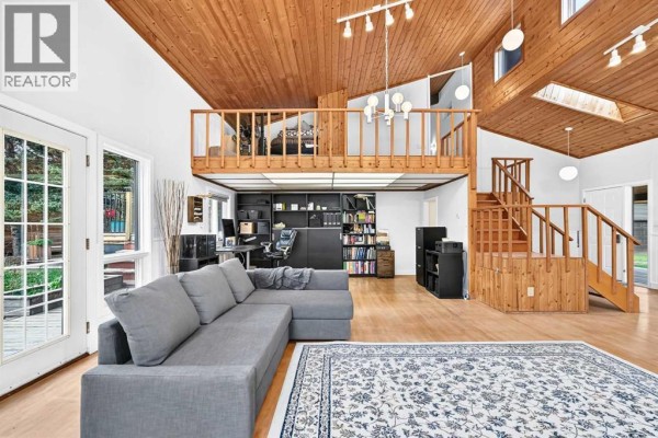 Spacious living area with a sectional sofa, loft, and staircase. - 16 Mountain View Park, Bragg Creek