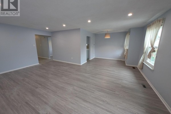 View of the kitchen from the other side showing the refrigerator and sink. - 16 Nortonville Drive, Toronto