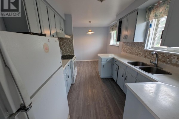 Spacious living room with light grey walls and grey wood-look flooring. - 16 Nortonville Drive, Toronto