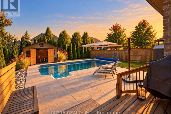 Front exterior of a modern house with grey brick and beige siding, driveway, and landscaping. - 16 Peregrine Avenue, Middlesex Centre
