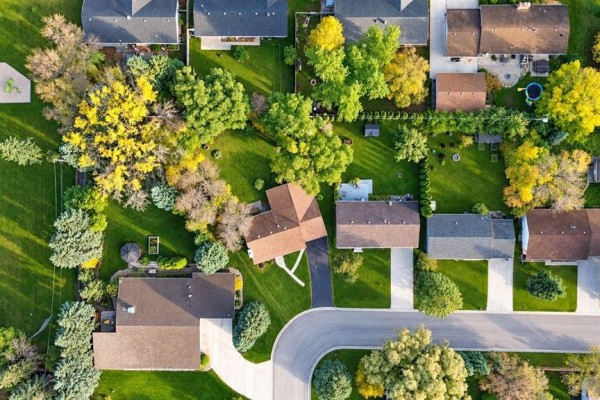 Aerial view of a residential street with houses and mature trees. - 16 Pine Crescent, Steinbach