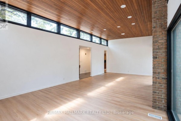 Bright living room with large windows, wood plank ceiling, and white walls. - 16 Royal Oak Drive, Toronto