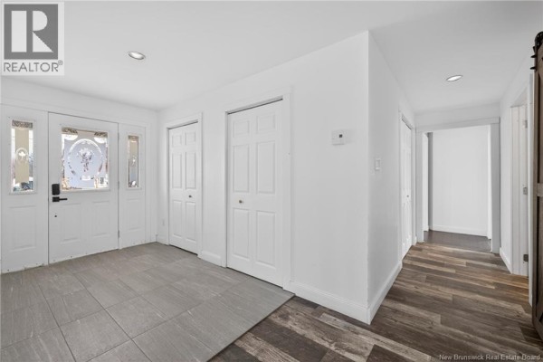 Interior hallway view showing a barn door, stairs, and open living space. - 16 Rue Du Rivage, Lameque